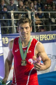 Clemente Russo mostra orgoglioso due pupazzetti rosa pensando alle piccole gemelline